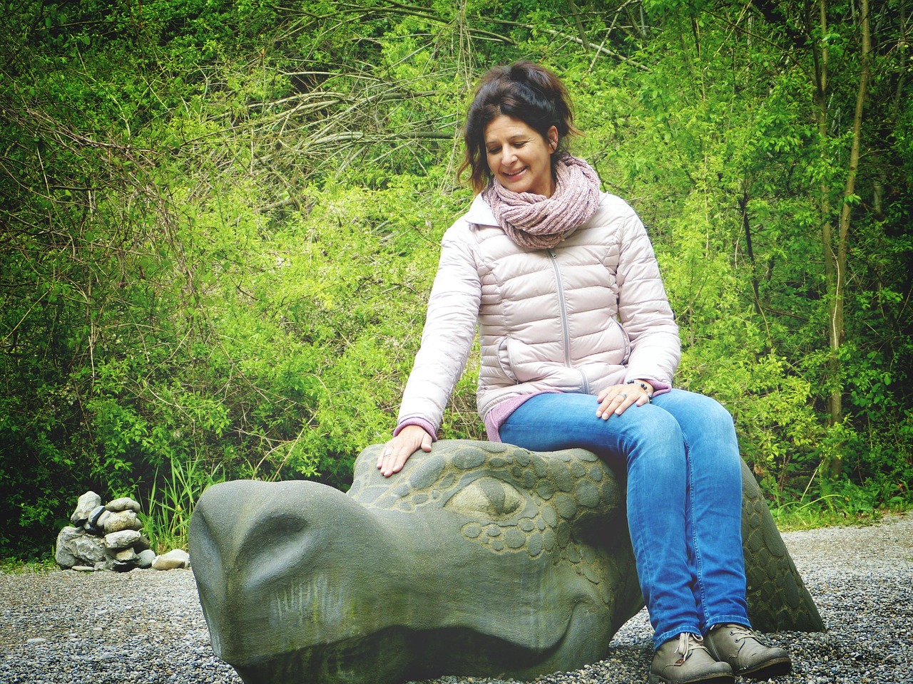 Scultura colorata nel Giardino dei Tarocchi in Toscana, con visitatori adulti e bambini in esplorazione.
