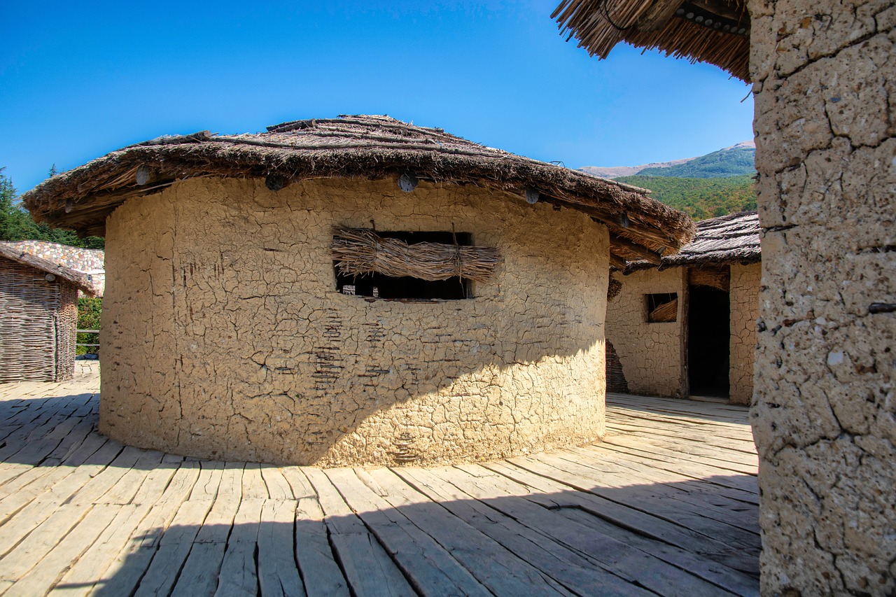 Borgo affollato con segnale di prenotazione obbligatoria e turisti in attesa.