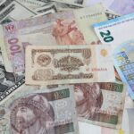 Banconote straniere di diverse valute su uno sfondo neutro, simbolo di valore e opportunità.