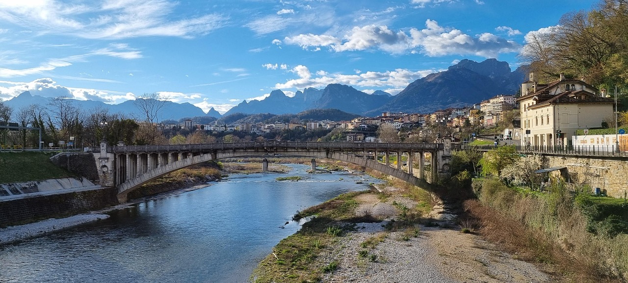Ponte degli Alpini a Bassano del Grappa, con vista sulla città e un bicchiere di spritz in primo piano.
