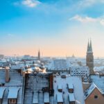 Panorama di una città innevata, con alberi e edifici coperti da un manto bianco d'inverno.