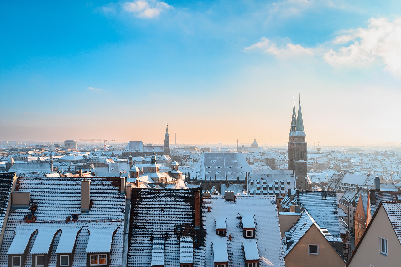 Panorama di una città innevata, con alberi e edifici coperti da un manto bianco d'inverno.