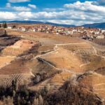 Panorama mozzafiato delle colline piemontesi, con vigneti e cieli azzurri.