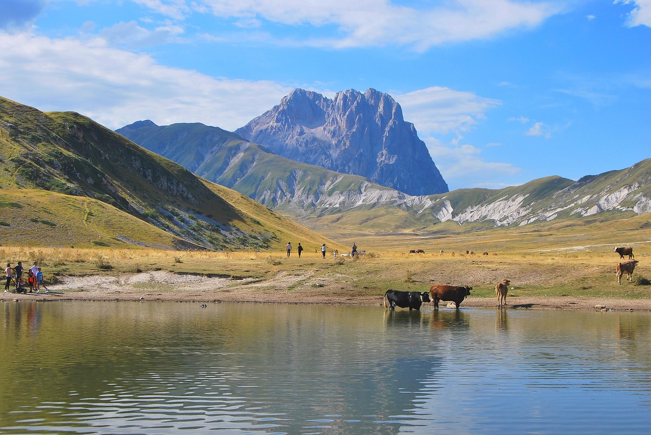 Vista panoramica del Lago di Scaffaiolo circondato da montagne verdi, ideale per il trekking.