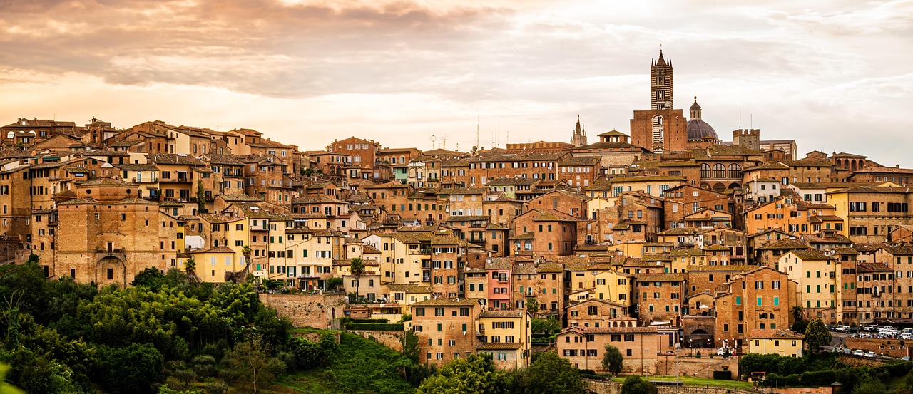 Vista panoramica di una città toscana con vigneti e turisti che degustano vino.