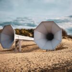 Spiaggia con sabbia che produce melodie al calpestio, circondata da cartelli di protezione ambientale.