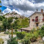 Paesaggio di un pittoresco villaggio italiano, con stradine acciottolate e case colorate.