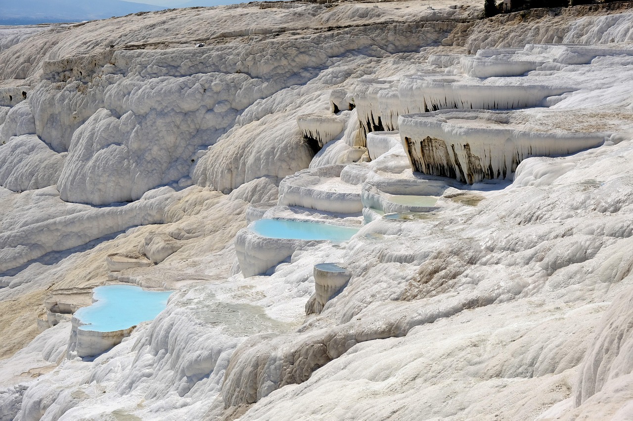 Vista panoramica della Scala dei Turchi recintata, con mare blu sullo sfondo e cielo sereno.