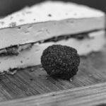 Immagine di un piatto di pasta al tartufo in un ristorante affollato durante la sagra del tartufo.