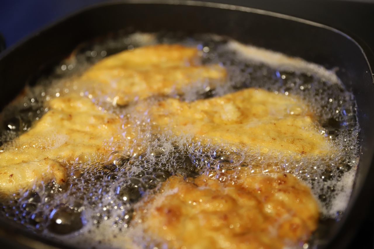 Immagine di una padella con olio freddo e ingredienti freschi pronti per essere soffritti.
