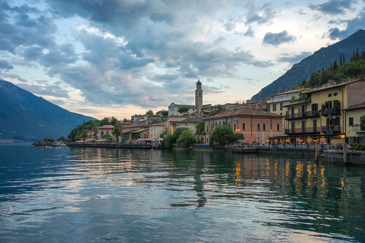 Tramonto sul lago italiano, con colori caldi che si riflettono sull'acqua serena.