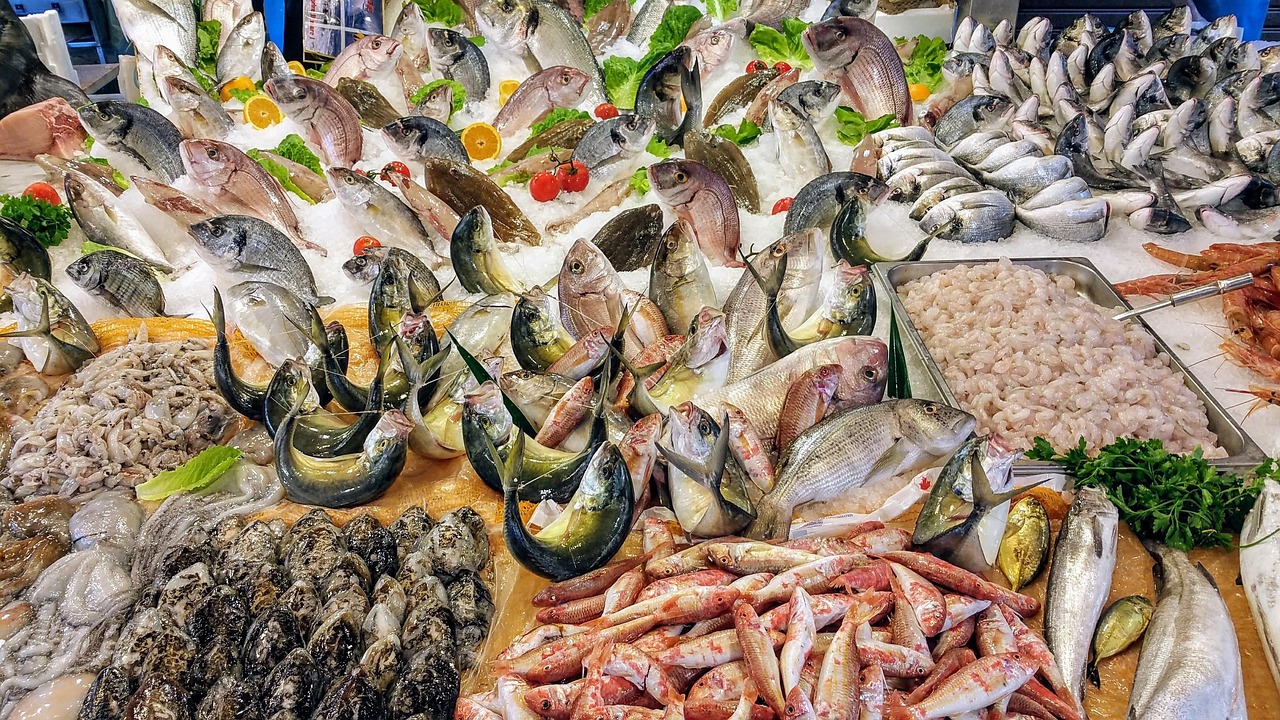 Mercato del pesce a Polignano a Mare, con bancarelle di pesce fresco e clienti in cerca di prodotti locali.