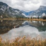 Lago di Fusine circondato da montagne, acque cristalline e vegetazione rigogliosa. Un angolo nascosto di bellezza naturale.
