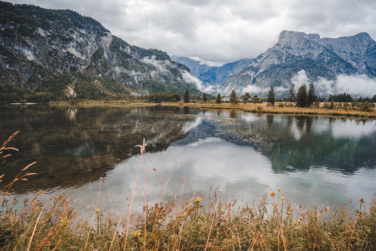 Lago di Fusine circondato da montagne, acque cristalline e vegetazione rigogliosa. Un angolo nascosto di bellezza naturale.