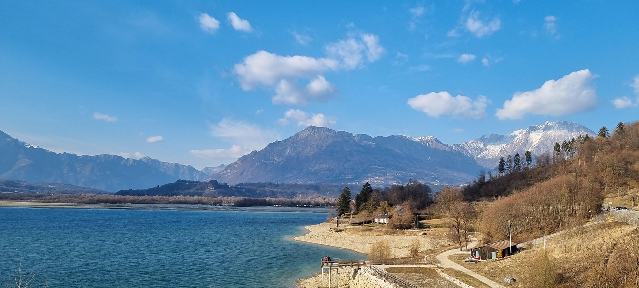 Vista panoramica del lago nascosto in Friuli, circondato da natura e montagne.
