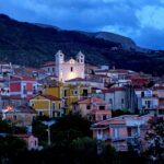 Panorama suggestivo di un caratteristico paese campano, con case colorate e paesaggi verdi.